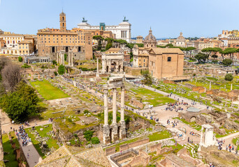 Fototapeta premium Rome, Italy - April 09, 2024: Ruins of the Roman Forum with tourists strolling among the archaeological remains in Rome, Italy