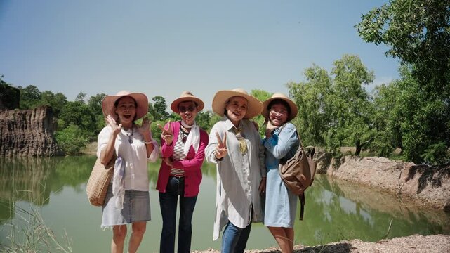 Elderly women Asia are friends, inviting each other go see nature after retirement, using pension money, posing beautifully on camera, recording their video with beautiful natural scenery.