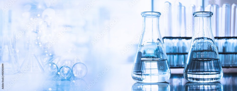 Wall mural flask and test tune in science research lab with blue banner background