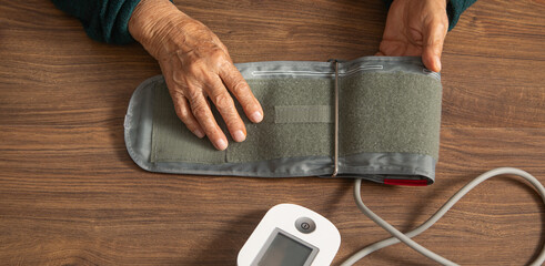 Measuring blood pressure of elderly woman at home.