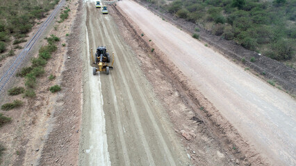 dirt road construction wits GPS grader and roller machines