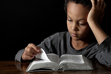 little boy praying to God with hands together on black background with people stock photo stock image