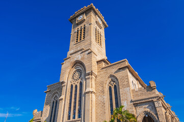 Clock Tower on Nha Trang Cathedral or Stone Church or Christ the King Cathedral in Vietnam on background a blue sky
