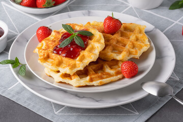 Waffles with strawberry jam and strawberries for breakfast