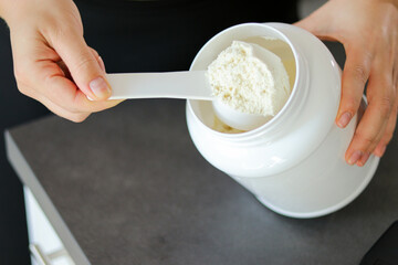 Close up of woman preparing a protein shake in the kitchen. Diet meal replacement for weight loss 
