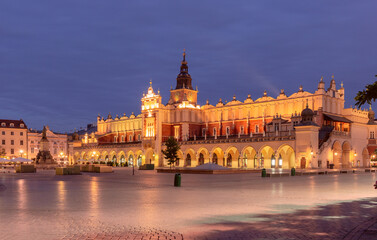 Naklejka premium The Cloth Hall in Krakow, Poland, photographed at dawn in the Main Market Square. The illuminated Renaissance-style building stands prominently with its arches and tower visible