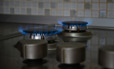 Blue flames burning on a gas stovetop in a modern kitchen