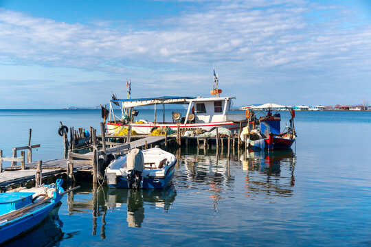 Fishing boats anchored on a pier at sunset, in Greece