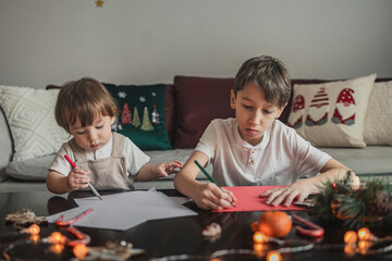 Siblings are  writing a letter to Santa Clause