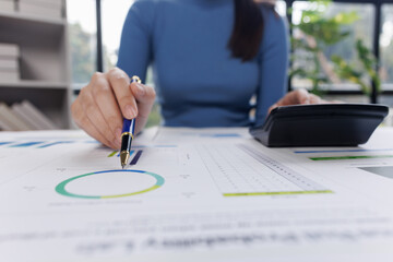 Close up of businesswoman uses a calculator to calculate business principles. Accounting statistical concepts at the office starting a financial business, calculating accounting online marketing.
