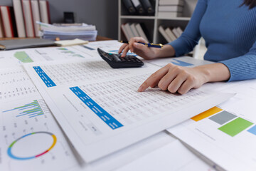 Close up of businesswoman uses a calculator to calculate business principles. Accounting statistical concepts at the office starting a financial business, calculating accounting online marketing.
