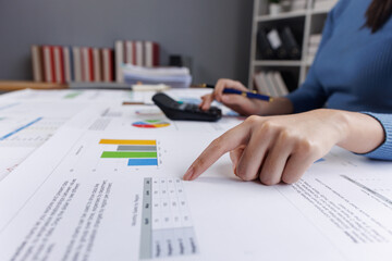 Close up of businesswoman uses a calculator to calculate business principles. Accounting statistical concepts at the office starting a financial business, calculating accounting online marketing.
