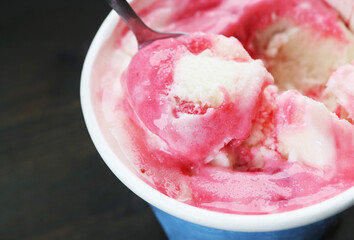 Closeup of strawberry yogurt ice cream on black wooden background