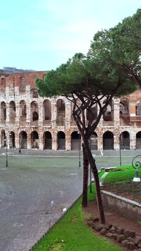 Il colosseo illuminato dal sole alle prime luci dell'alba. Roma, Italia.
Vista erea del colosseo con i raggi del sole che attraversano gli archi. Video Verticale. 
