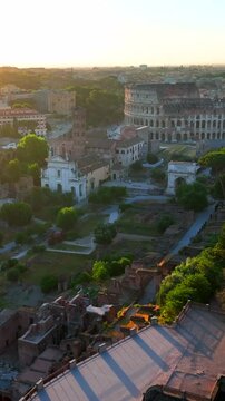 Il colosseo illuminato dal sole alle prime luci dell'alba. Roma, Italia.
Vista erea del colosseo con i raggi del sole che attraversano gli archi. Video Verticale. 
