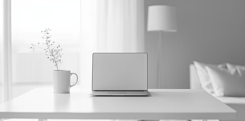 Minimalist white office desk with laptop and coffee mug on a blurred background, with space for text, representing the concept of working from home