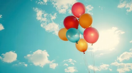 Vibrant balloons float against a clear blue sky, adding a joyful touch to any celebration or festive occasion.