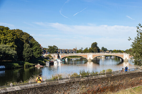 Hampton Court Bridge viewed from Hampton Court Palace with runners on the River Thames footpath