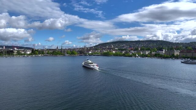 Swiss Ferry floating on Zurichsee lake in Switzerland. Passenger Ship is approaching Zurich City at Morning. Aerial shot