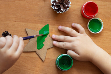 child draws with paints, hands close-up