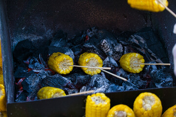 Corn cobs stuck on toothpicks, placed on the grill - wood-fired corn