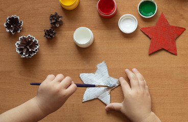 a child paints stars from cardboard. christmas decor