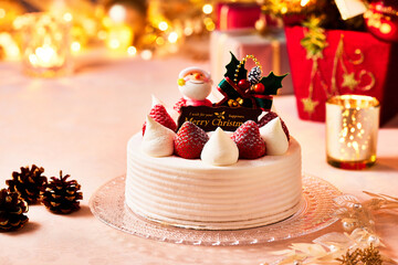 クリスマスケーキ、ガラス製のお皿に生クリームとイチゴのケーキ黄金に輝く贅沢なイメージ