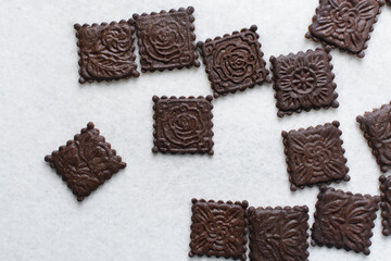 Overhead view of stamped molasses cookies on a parchment lined baking tray, top view of embossed...