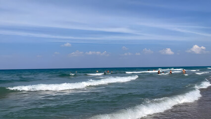 Greek sea waves sky without clouds in the distance people are swimming