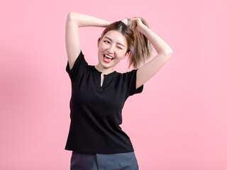 Half body photo cute happy fun young Asian beautiful female, woman smiling in a black t-shirt and enjoy poses  isolated plain pastel light over pink color wall background