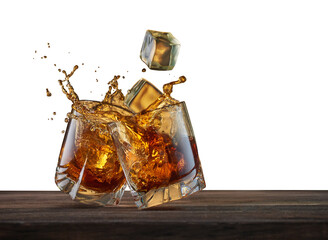 Two glasses with whiskey and falling ice cubes on a wooden table. Concept for advertising alcoholic...