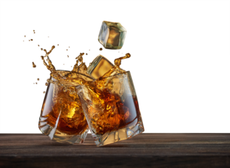 Two glasses with whiskey and falling ice cubes on a wooden table. Concept for advertising alcoholic beverages with ice cubes, glasses and splashes.