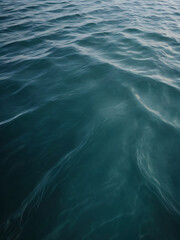 Waves in varying shades of blue converge on the ocean surface.