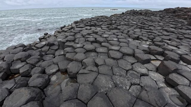 Static footage of Giant Causeway in Northern Ireland showing the unique basalt columns along the Atlantic coast with waves hitting the rocky shoreline