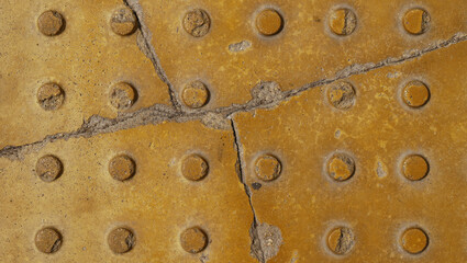 The texture of yellow-painted concrete with cracks