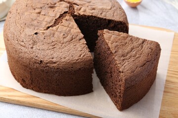 Cut chocolate sponge cake on table, closeup