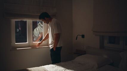 Man sitting sorrowfully bed at window moonlight. Male suffering sleep problem