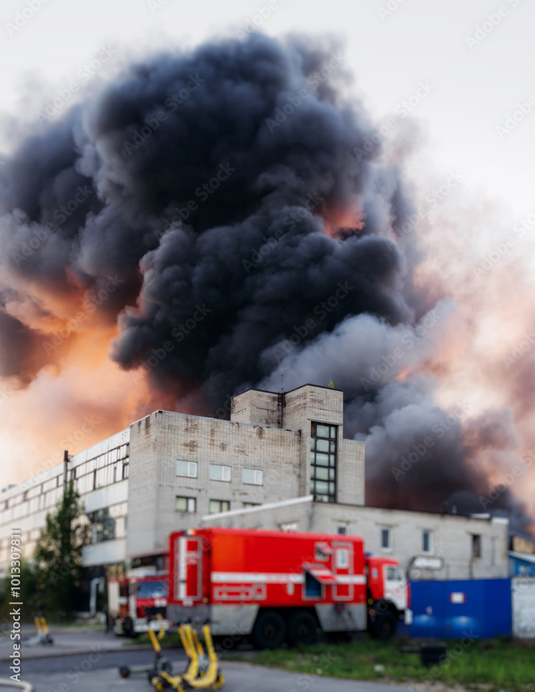 Wall mural massive large blaze fire in the city with large column plume of smoke, blazing warehouse factory, st