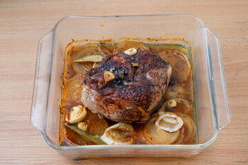 Delicious roasted lamb shank in a glass baking dish, beautifully browned and garnished with herbs, capturing the essence of home-cooked comfort food. © Jmanita