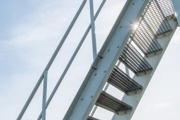 steel staircase with steps made of perforated sheet metal against the light