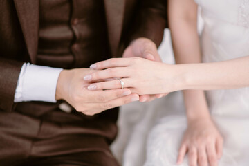 Wedding engagement rings. Groom put a wedding ring on finger of his bride at a wedding ceremony. Close-up. Newlyweds.