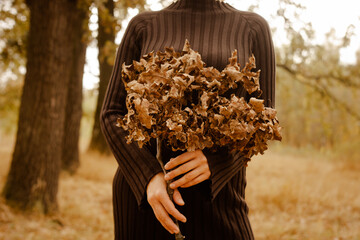 a large dry oak branch held by a girl in her hands