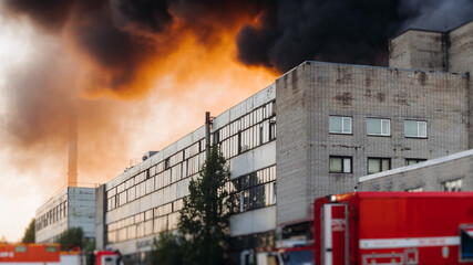 Massive large blaze fire in the city, blazing warehouse factory, storage building is burning,...
