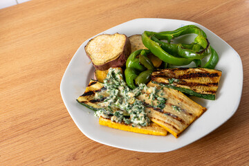 Grilled tofu and vibrant vegetables drizzled with a creamy peanut pesto, beautifully plated to highlight their colors and textures. Perfect for healthy food photography.