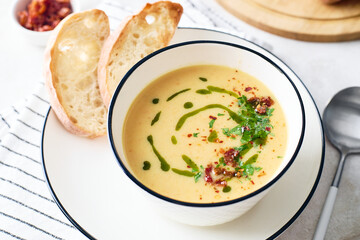 Bowl of potato soup with parsley and bacon with toasted bread croutons in white bowl. Comfort meal
