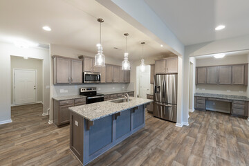 Large Open Kitchen and Workspace. Open kitchen with an island, granite countertops, stainless steel appliances, and a built-in workstation. Investment, renting, or homeownership concept.