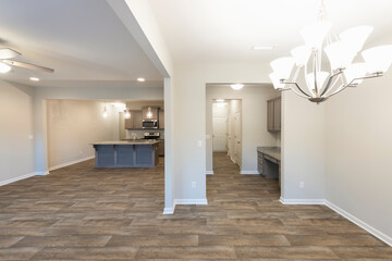 Empty modern townhouse floor showcasing a kitchen, a workspace, living, and dinning room ready to be moved in. Investment, renting, or house ownership concept.