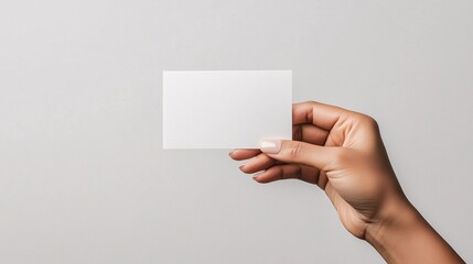 Obraz premium Hand Holding Blank Business Card on Neutral Background