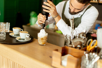 Barista skillfully prepares a creamy dessert coffee in a cozy café setting during the vibrant...