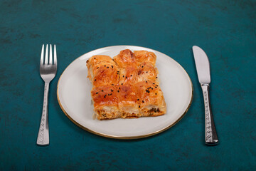 Plate of Turkish Cheese Borek with Fork and Knife – Flaky Pastry with Sesame Seeds, Ideal for Traditional Turkish Cuisine and Mediterranean Food Presentations